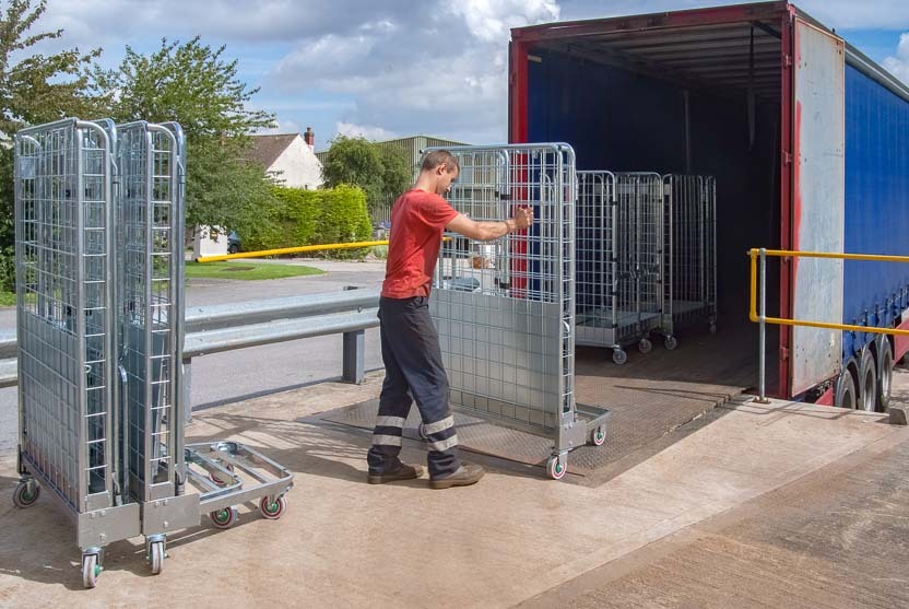 Un empleado carga roll containers alquilados de cajas en un camión semirremolque